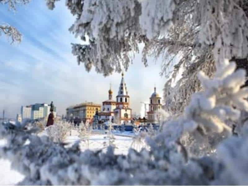 Зимний пейзаж с церковью и снежными деревьями.