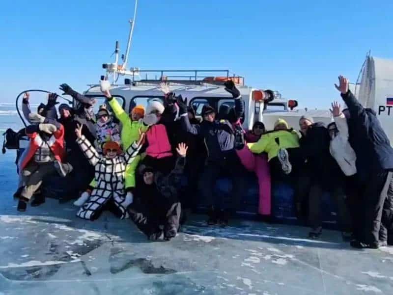 Группа людей на лодке в зимний период, веселье и активный отдых на воде.